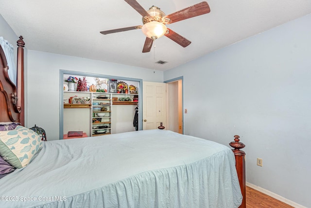 bedroom featuring ceiling fan, a closet, and hardwood / wood-style flooring