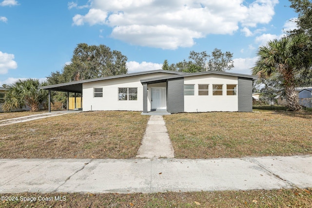 view of front of house with a carport and a front lawn