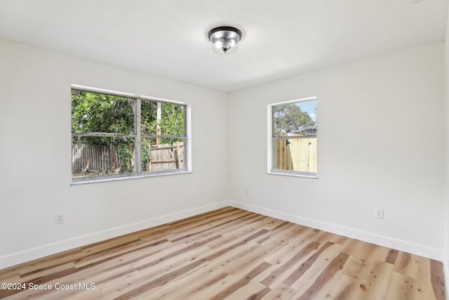 spare room featuring plenty of natural light and light hardwood / wood-style flooring