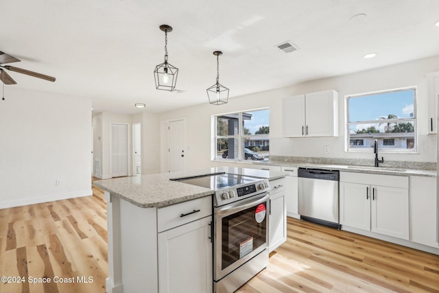 kitchen featuring appliances with stainless steel finishes, a wealth of natural light, sink, light hardwood / wood-style floors, and white cabinetry