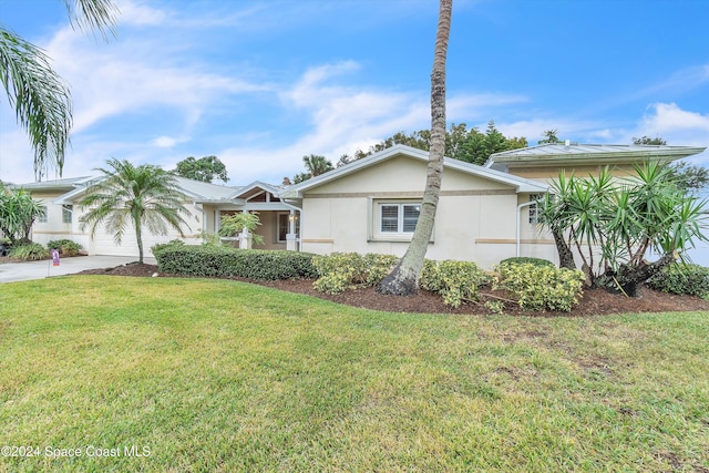 single story home featuring a front yard and a garage