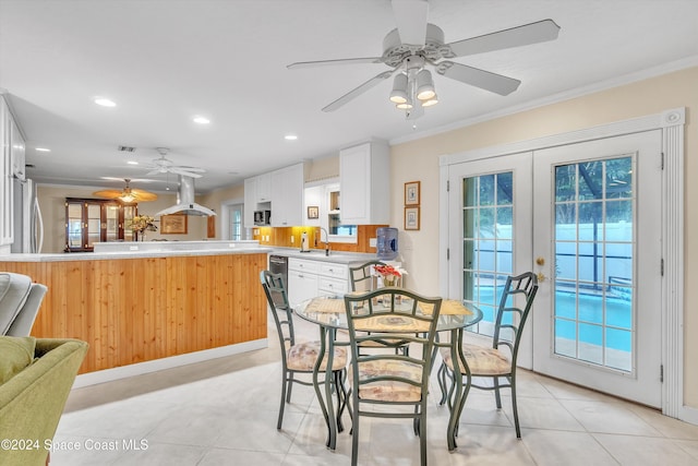 tiled dining space with crown molding, sink, and french doors