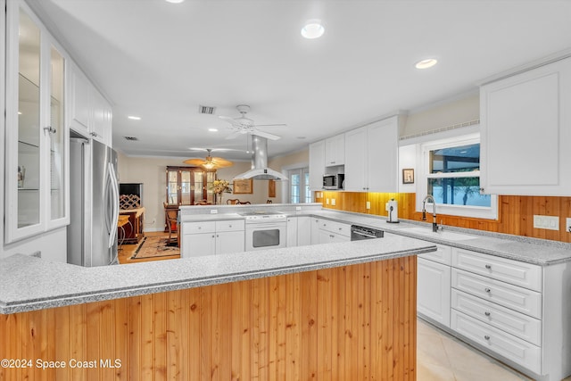 kitchen with white cabinets, sink, island range hood, kitchen peninsula, and stainless steel appliances