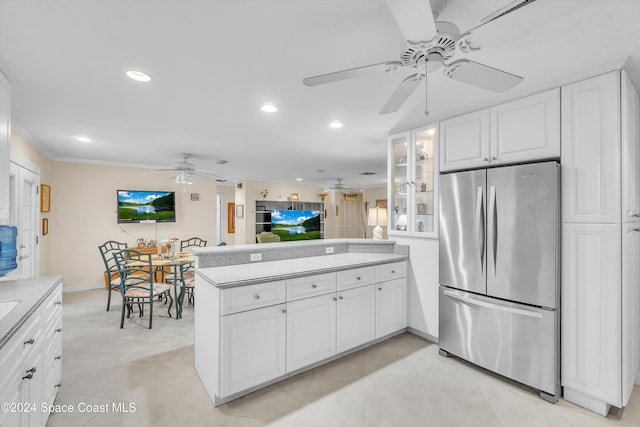 kitchen featuring stainless steel refrigerator, white cabinetry, kitchen peninsula, and crown molding