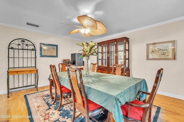 dining space featuring ceiling fan, light hardwood / wood-style floors, and crown molding