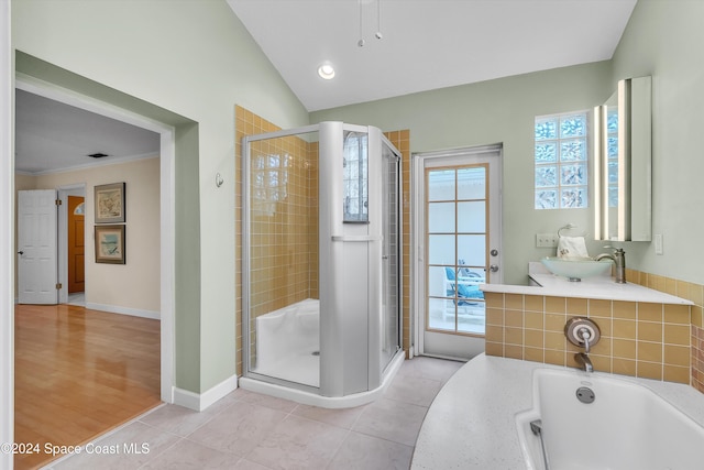 bathroom featuring tile patterned flooring, a shower with shower door, vaulted ceiling, and ornamental molding