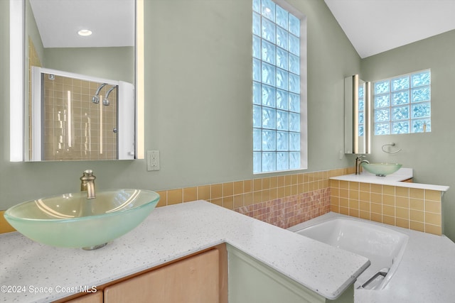 bathroom with vanity, plus walk in shower, a wealth of natural light, and vaulted ceiling