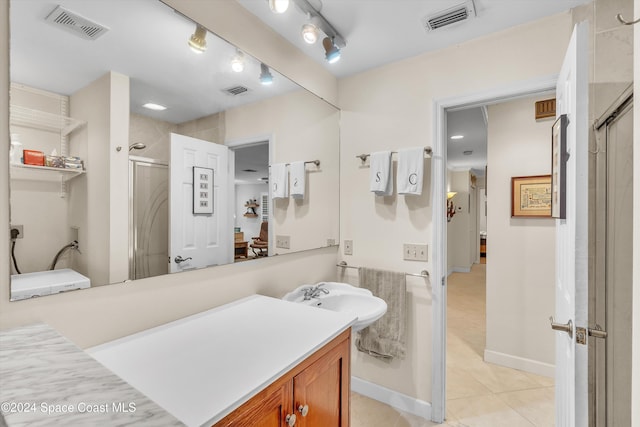 bathroom with tile patterned flooring, vanity, and a shower with shower door