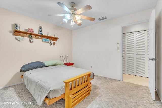 bedroom with ceiling fan, a closet, and light colored carpet