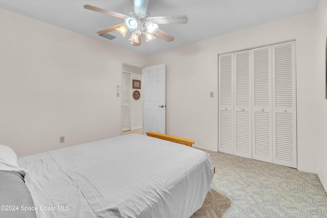 carpeted bedroom with ceiling fan and a closet