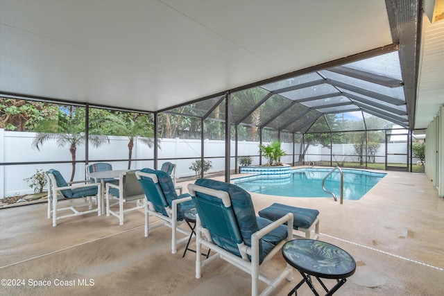 view of pool with glass enclosure and a patio area