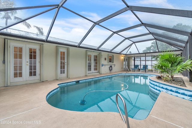 view of swimming pool featuring a lanai, a patio area, and french doors