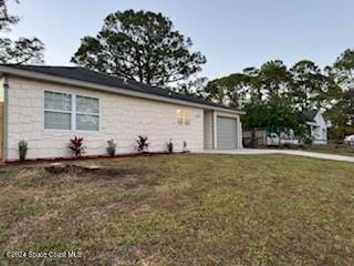 view of property exterior featuring a yard and a garage