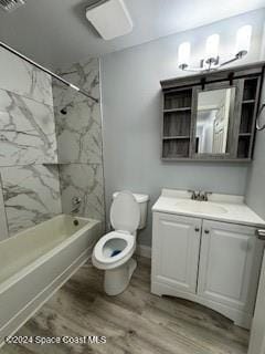 full bathroom featuring hardwood / wood-style flooring, vanity, toilet, and tiled shower / bath