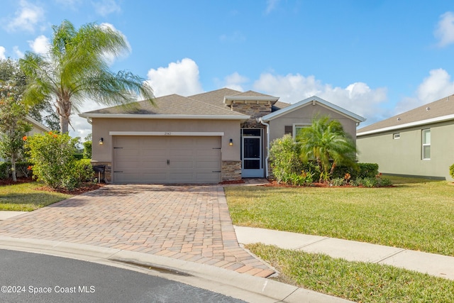 2342 Planter Ridge Ct, Palm Bay, FL 32909 - view of front of house featuring stone siding, stucco siding, decorative driveway, a garage, and a front yard