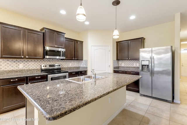 2342 Planter Ridge Ct, Palm Bay, FL 32909 - kitchen with appliances with stainless steel finishes, dark brown cabinets, tasteful backsplash, pendant lighting, and an island with sink