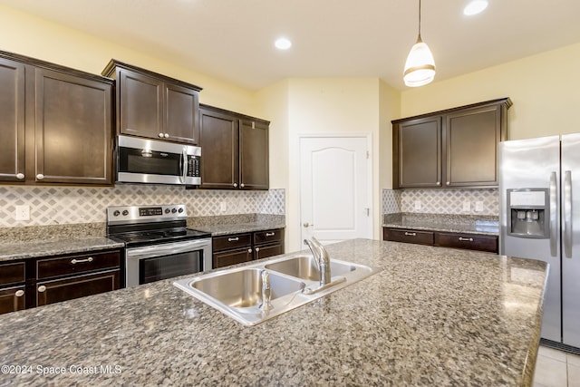 2342 Planter Ridge Ct, Palm Bay, FL 32909 - kitchen featuring stainless steel appliances, dark brown cabinets, backsplash, hanging light fixtures, and dark stone counters