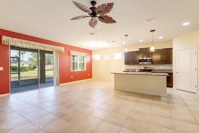 2342 Planter Ridge Ct, Palm Bay, FL 32909 - kitchen with stainless steel appliances, ceiling fan, tasteful backsplash, open floor plan, and dark brown cabinetry
