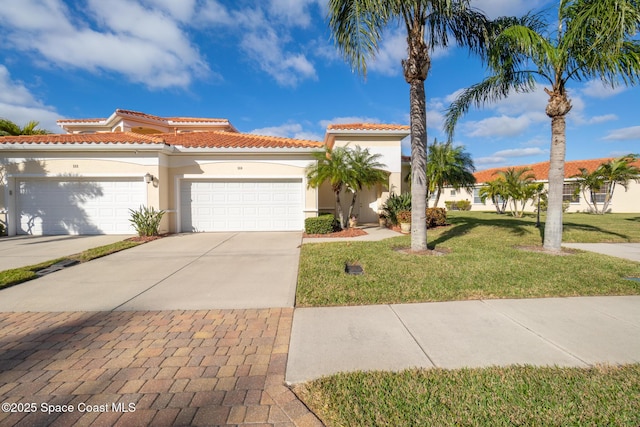 mediterranean / spanish-style home with a front lawn and a garage