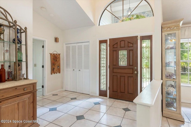 tiled entrance foyer featuring high vaulted ceiling