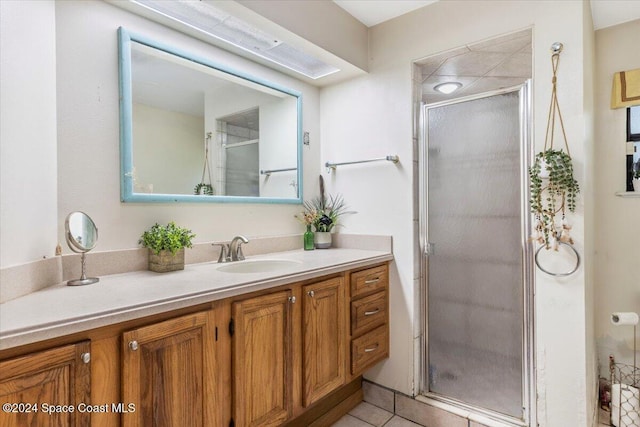 bathroom with tile patterned floors, vanity, and walk in shower