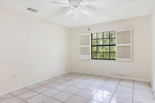 empty room with ceiling fan and light tile patterned floors