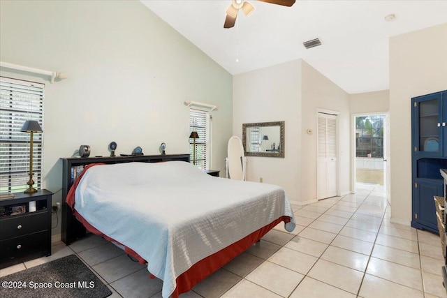 tiled bedroom featuring ceiling fan, high vaulted ceiling, and a closet