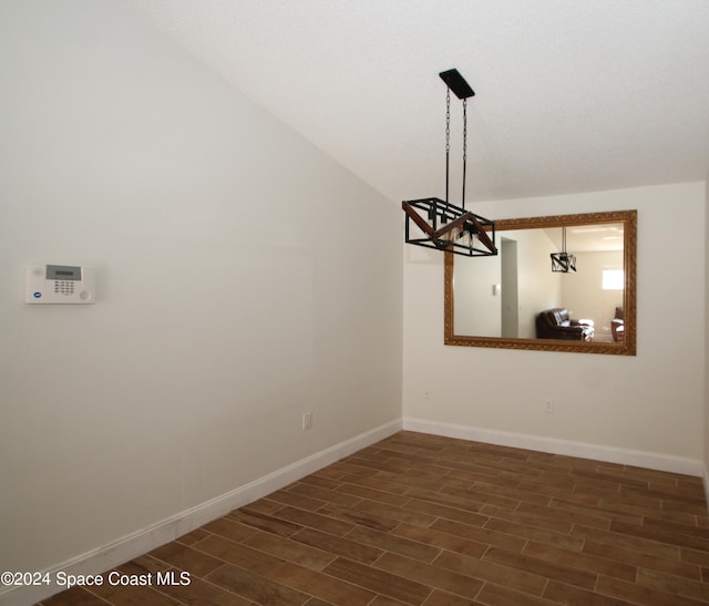 unfurnished dining area with lofted ceiling and dark hardwood / wood-style floors