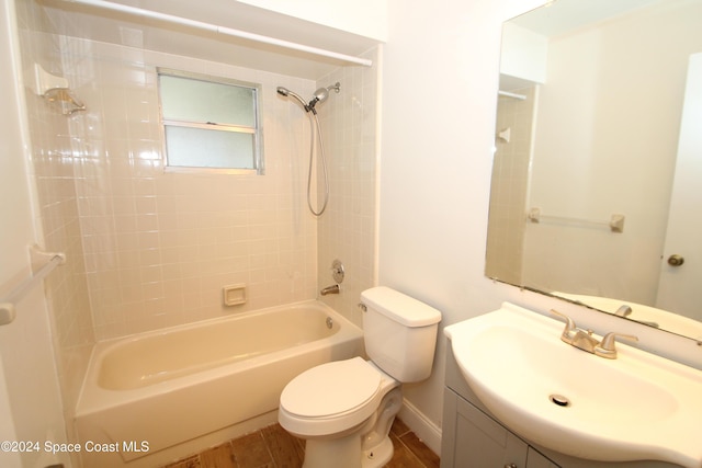 full bathroom with hardwood / wood-style flooring, vanity, toilet, and tiled shower / bath combo