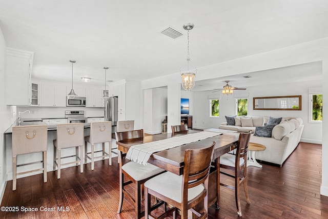 dining space featuring ceiling fan, dark wood-type flooring, and sink