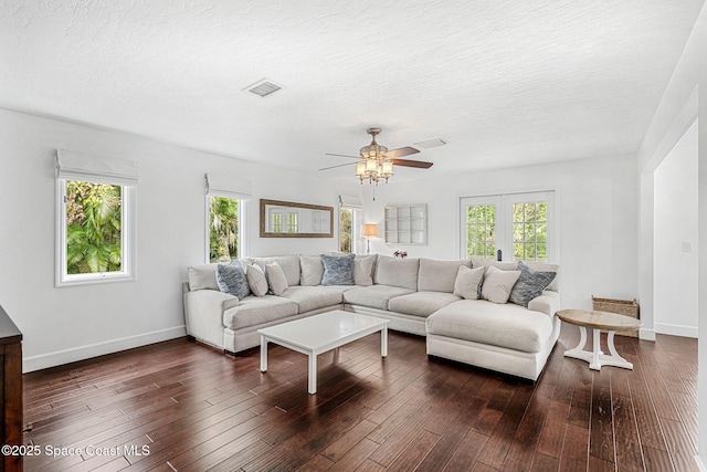 living room featuring a textured ceiling, ceiling fan, and dark hardwood / wood-style floors