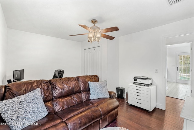 living room with ceiling fan and dark hardwood / wood-style flooring