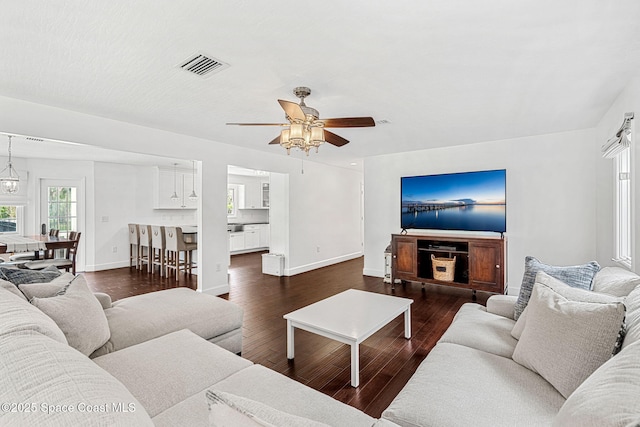 living room featuring dark hardwood / wood-style flooring and ceiling fan