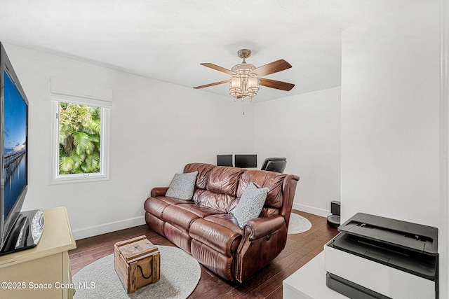 living room featuring ceiling fan and dark wood-type flooring