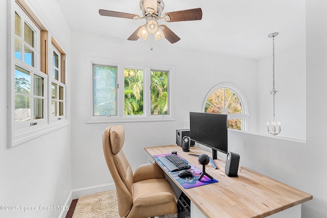 office space featuring ceiling fan with notable chandelier and plenty of natural light