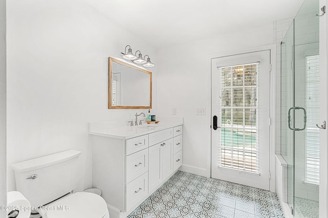 bathroom featuring plenty of natural light, toilet, an enclosed shower, and vanity