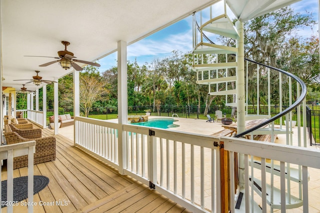 wooden deck with ceiling fan and a fenced in pool