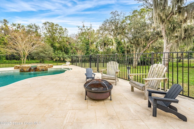 view of patio / terrace featuring a pool with hot tub and an outdoor fire pit