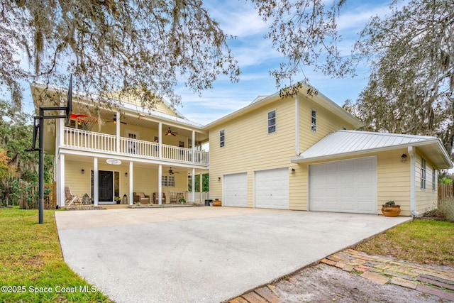 back of property with ceiling fan, a balcony, a porch, and a garage