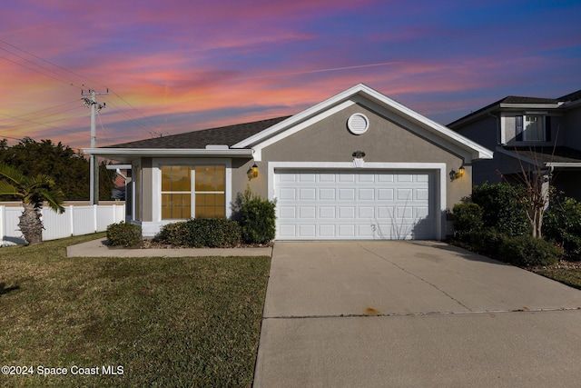 view of front of property with a garage and a lawn