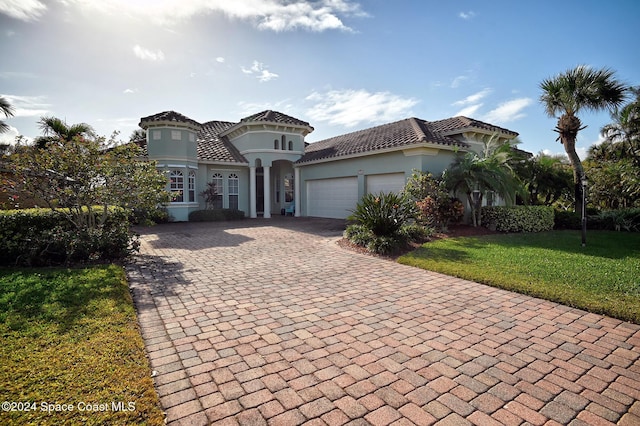 mediterranean / spanish-style house featuring a garage and a front lawn