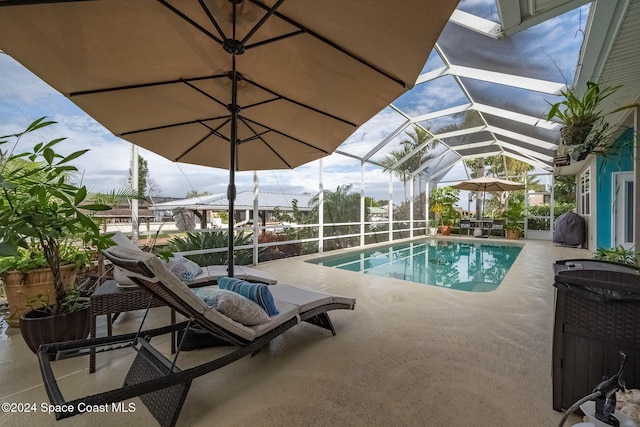 view of swimming pool with area for grilling, a patio area, and glass enclosure