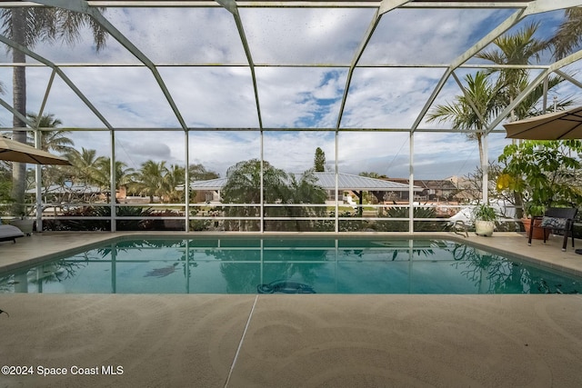 view of swimming pool with a patio and glass enclosure