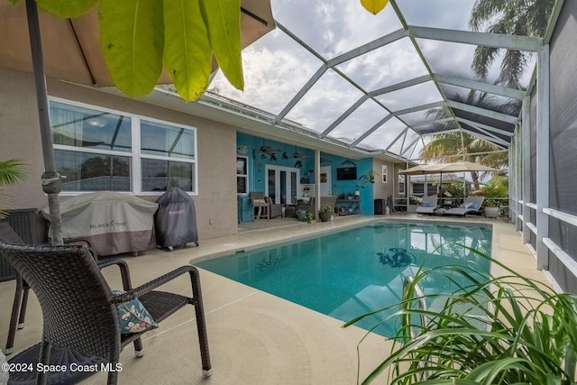 view of swimming pool featuring a patio area, french doors, ceiling fan, and glass enclosure