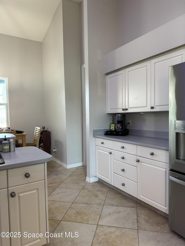 kitchen featuring stainless steel refrigerator with ice dispenser and white cabinetry