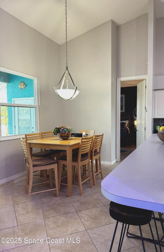 tiled dining area featuring lofted ceiling