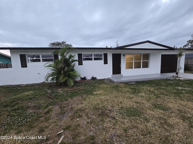 ranch-style home featuring a garage and a front lawn