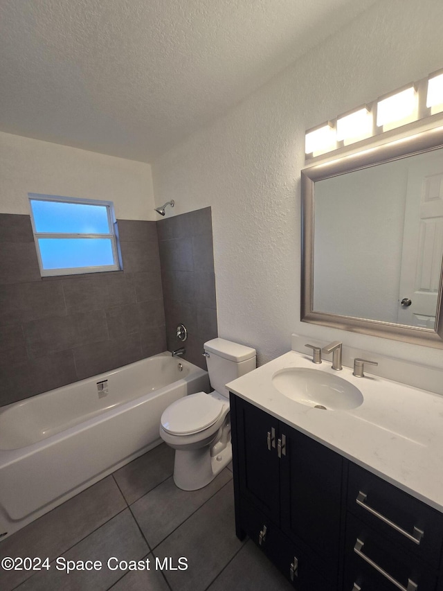 full bathroom with tile patterned flooring, a textured ceiling, toilet, vanity, and tiled shower / bath