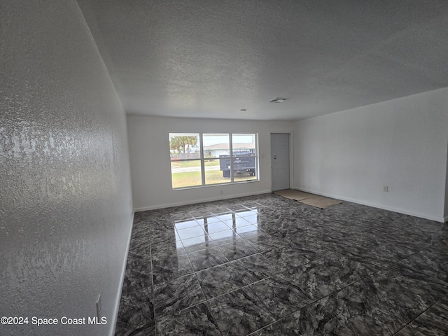 spare room with a textured ceiling