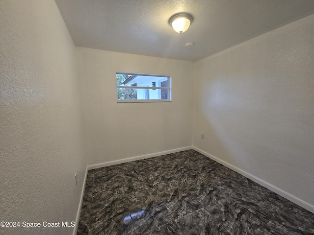 spare room with a textured ceiling